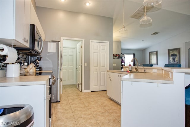 kitchen featuring white cabinetry, sink, decorative light fixtures, lofted ceiling, and light tile patterned flooring