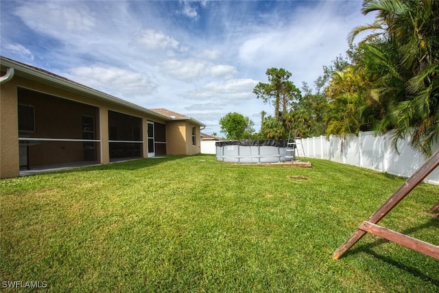 view of yard with a fenced in pool and a sunroom