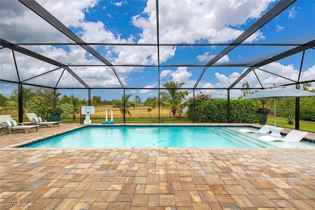 view of swimming pool featuring glass enclosure and a patio area