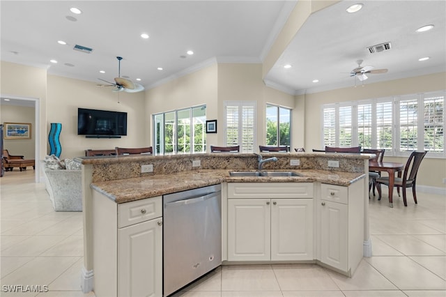 kitchen featuring an island with sink, sink, white cabinets, and stainless steel dishwasher