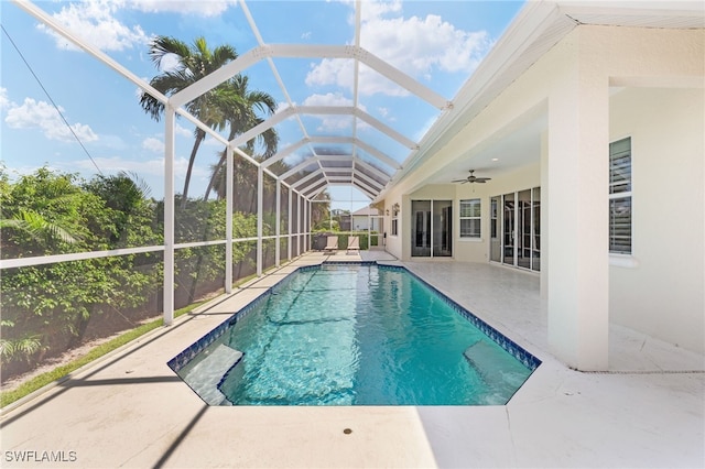 view of swimming pool with ceiling fan, a patio area, and a lanai