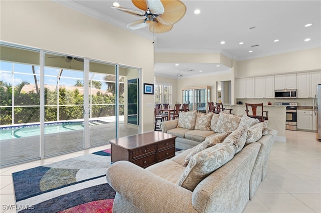 living room with ceiling fan, light tile patterned floors, and ornamental molding