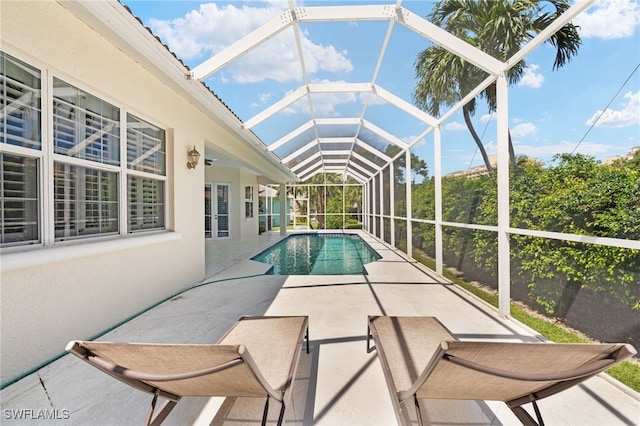 view of swimming pool featuring a lanai and a patio