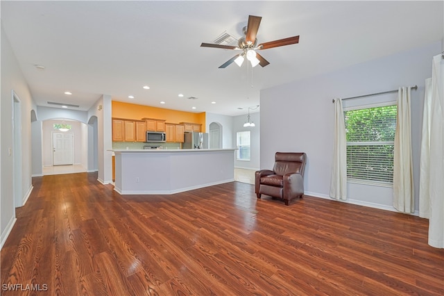 unfurnished living room with ceiling fan with notable chandelier and dark hardwood / wood-style flooring