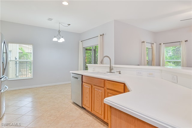 kitchen featuring sink, hanging light fixtures, stainless steel appliances, a notable chandelier, and light tile patterned floors