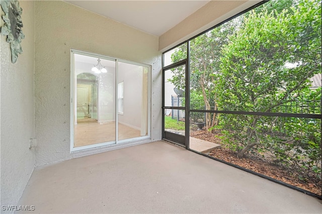 unfurnished sunroom featuring a chandelier