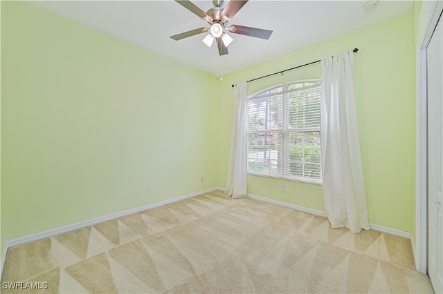 spare room featuring ceiling fan and light carpet