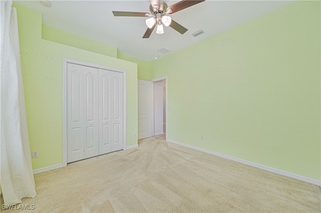 unfurnished bedroom with light carpet, a closet, and ceiling fan