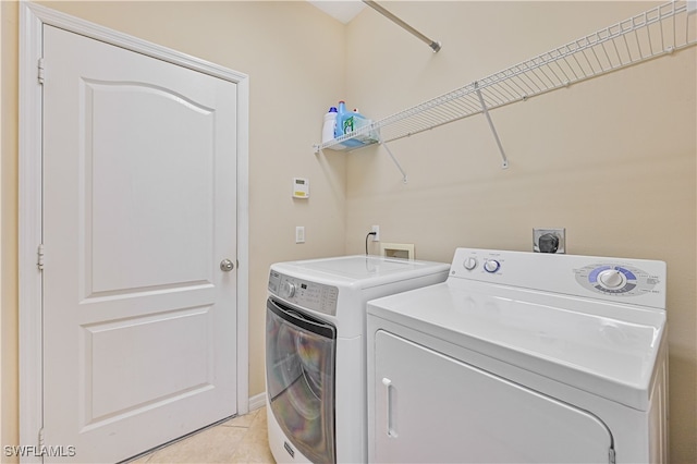 laundry room with light tile patterned floors and washing machine and clothes dryer