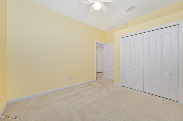 unfurnished bedroom with a closet, ceiling fan, and light colored carpet