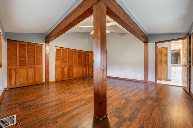 interior space featuring vaulted ceiling with beams and dark hardwood / wood-style floors