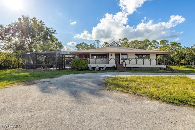 view of front of home with a lanai and a front lawn