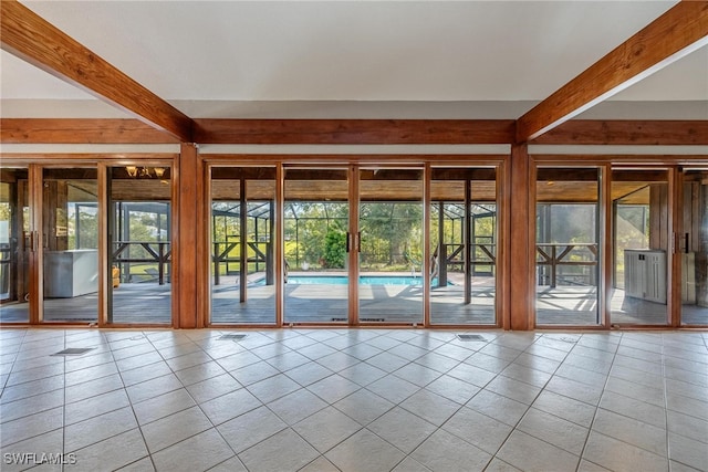 entryway featuring beamed ceiling and light tile patterned floors