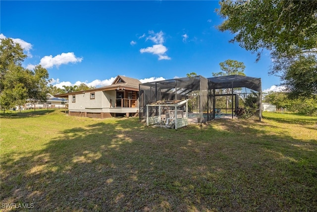 back of property with a lawn, a lanai, and a pool