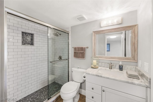 bathroom with vanity, toilet, and a shower with door