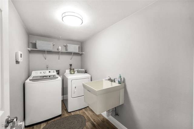 washroom featuring wood-type flooring, sink, and washing machine and clothes dryer