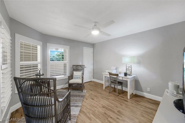 home office with light hardwood / wood-style flooring and ceiling fan