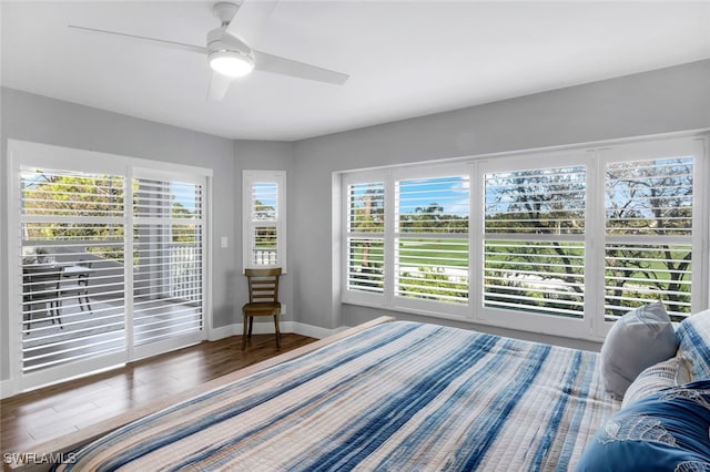 bedroom with ceiling fan, access to exterior, and dark wood-type flooring