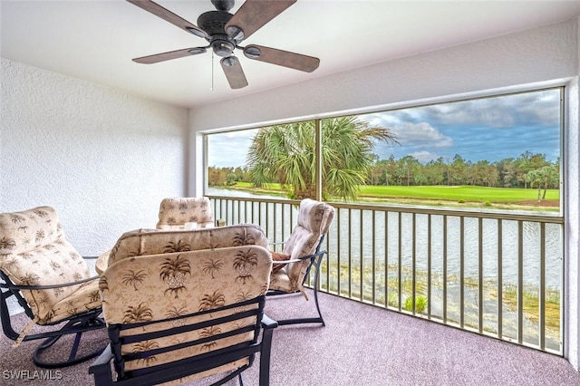 sunroom / solarium featuring ceiling fan and a water view