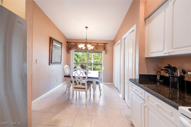 tiled dining area with a chandelier and vaulted ceiling