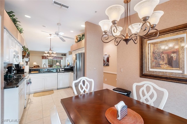 tiled dining room with ceiling fan and sink