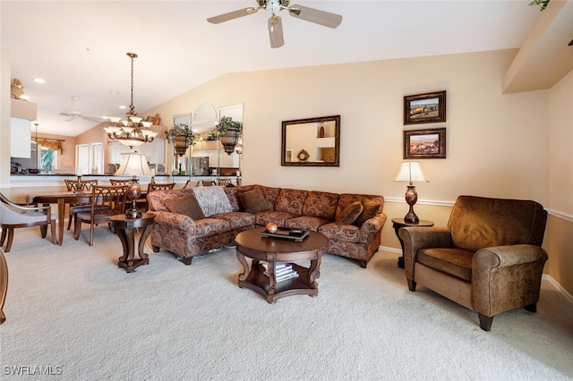 carpeted living room featuring ceiling fan with notable chandelier and vaulted ceiling