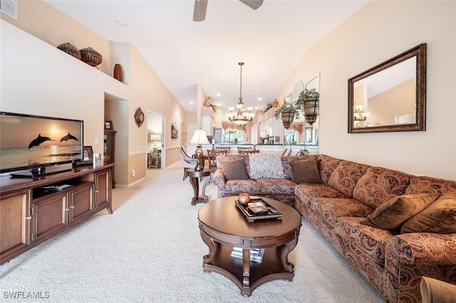 carpeted living room featuring ceiling fan with notable chandelier and lofted ceiling