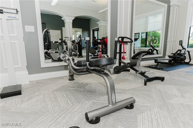 exercise room featuring carpet floors and decorative columns