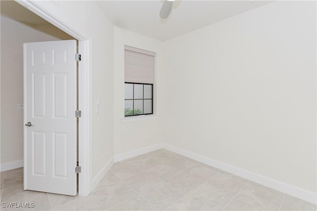 tiled spare room featuring ceiling fan