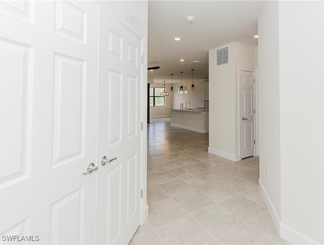 hallway with sink and light tile patterned flooring