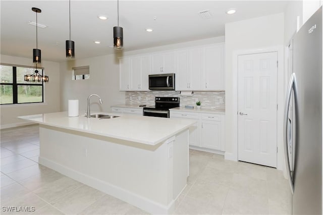 kitchen with sink, hanging light fixtures, stainless steel appliances, white cabinets, and a center island with sink