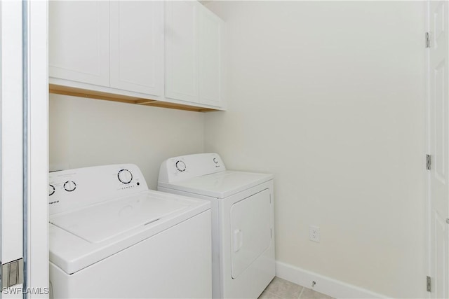 laundry area with cabinets, light tile patterned floors, and washer and dryer