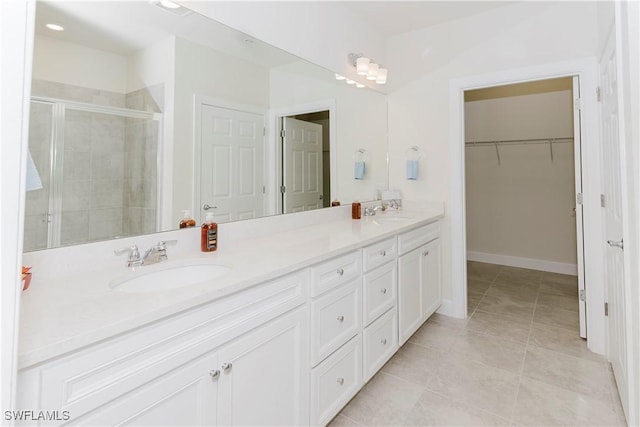 bathroom featuring vanity, a shower with shower door, and tile patterned floors