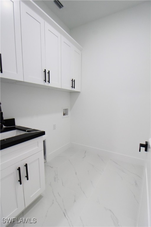 laundry room featuring hookup for a washing machine and cabinets