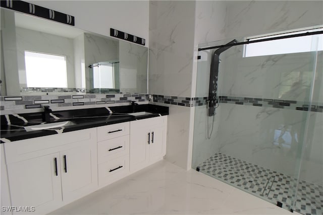 bathroom featuring decorative backsplash, a tile shower, vanity, and a healthy amount of sunlight