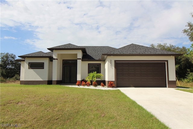 prairie-style home with a garage and a front lawn