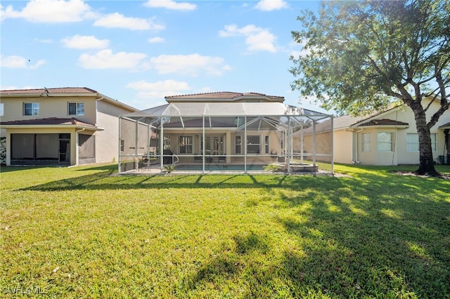 rear view of house featuring a lawn, glass enclosure, and a swimming pool