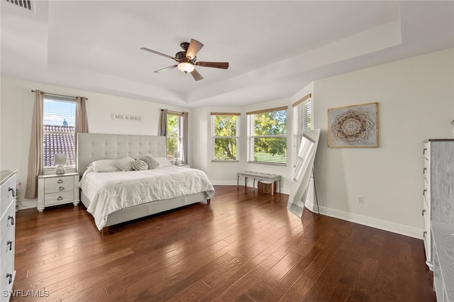 bedroom featuring dark hardwood / wood-style floors, multiple windows, and ceiling fan