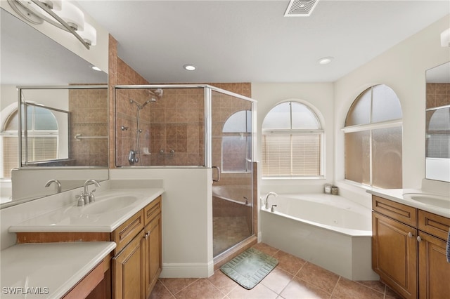 bathroom with vanity, tile patterned flooring, and plus walk in shower