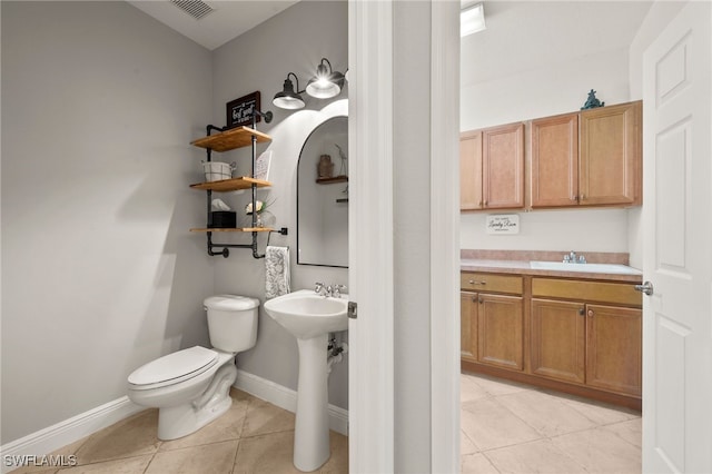 bathroom featuring toilet, tile patterned floors, and sink