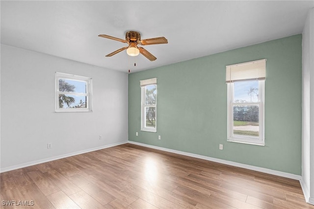 empty room featuring ceiling fan, baseboards, and wood finished floors