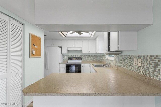 kitchen with sink, kitchen peninsula, white fridge, electric stove, and white cabinets