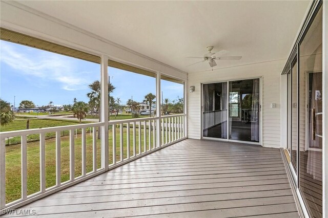 wooden deck with ceiling fan and a lawn