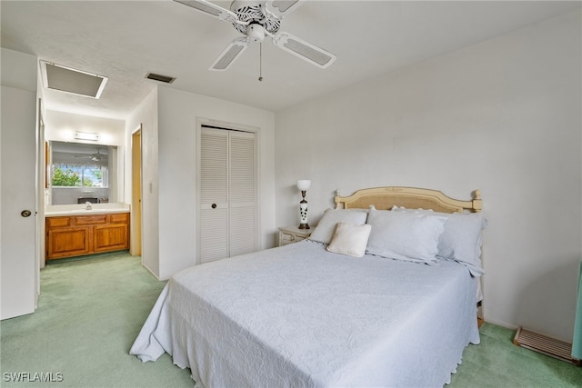 bedroom featuring connected bathroom, ceiling fan, a closet, and light carpet