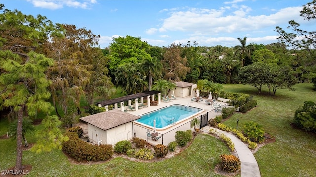 view of swimming pool with a lawn, a patio area, and an outdoor structure