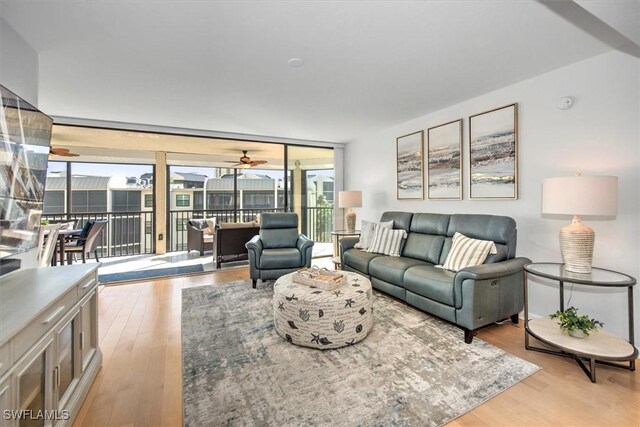 living room featuring ceiling fan and light hardwood / wood-style flooring