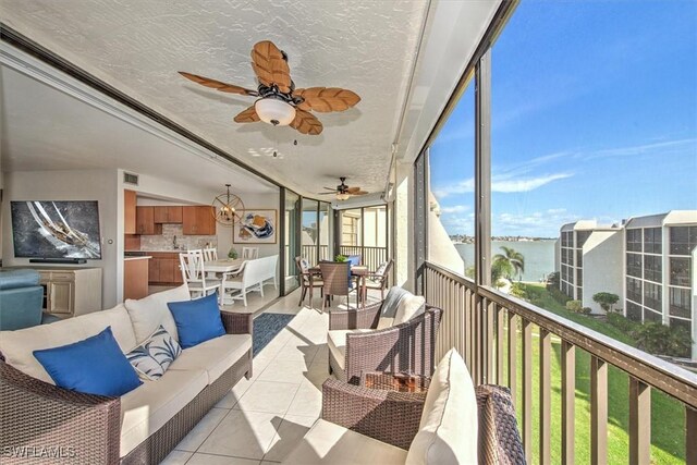 sunroom / solarium featuring a water view and ceiling fan