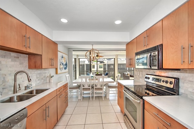 kitchen featuring hanging light fixtures, sink, appliances with stainless steel finishes, light tile patterned flooring, and a chandelier