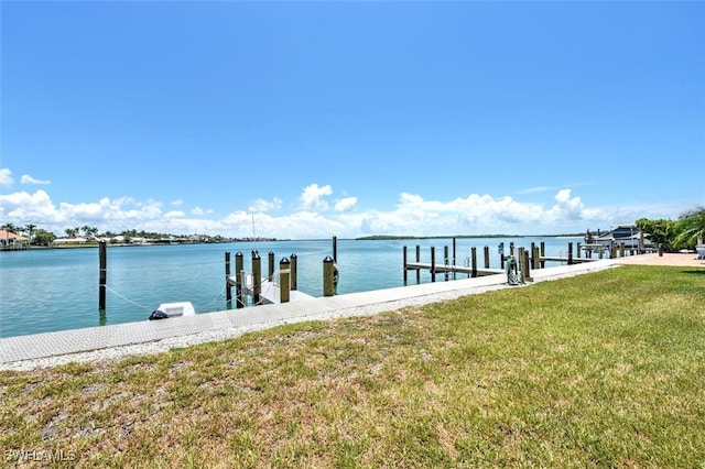 dock area with a lawn and a water view