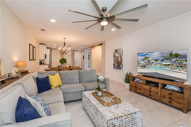 tiled living room with ceiling fan with notable chandelier